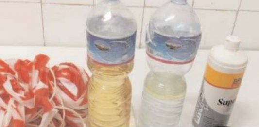Stir, operaio fermato con una bottiglia di liquido infiammabile