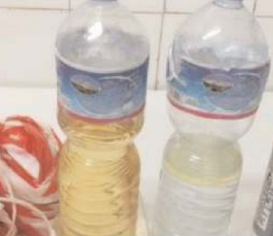 Stir, operaio fermato con una bottiglia di liquido infiammabile