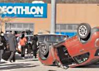 Scontro nel piazzale del centro commerciale, auto si ribalta